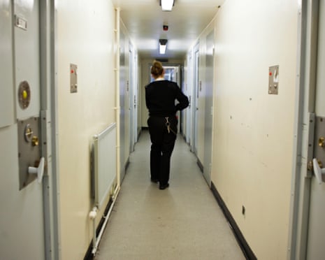 Prison officer walks down corridor in residential prison wing
