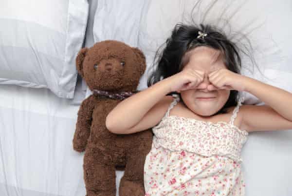 Little girl looking upset on bed (Posed by model)