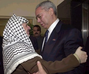 Powell embracing the Palestinian leader Yasser Arafat as they met for talks in Ramallah in 2001