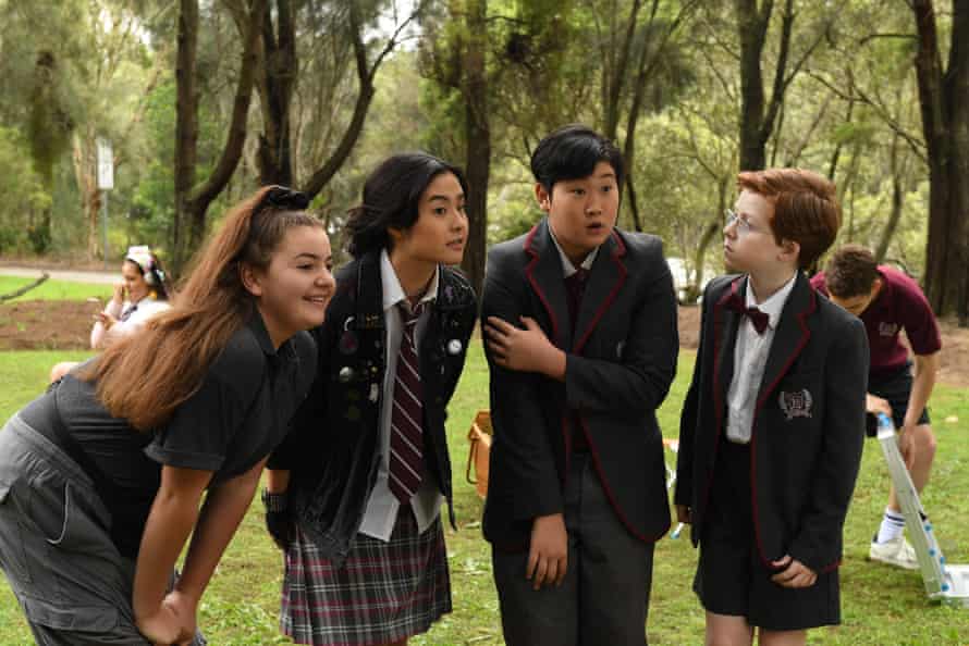 A group of teens in school uniforms in a park