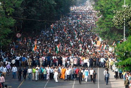 Marchers with Indian flags and political banners fill a wide avenue in Kolkata