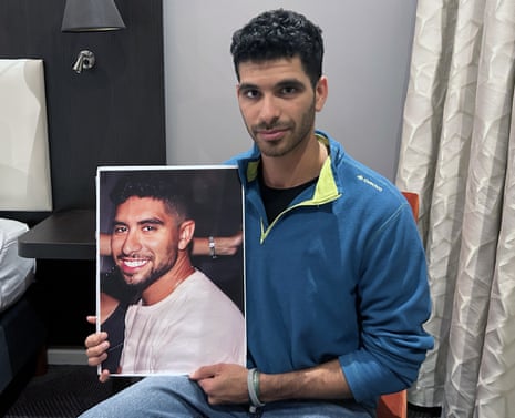 Ilay David holds a picture of his brother Evyatar taken before his kidnapping