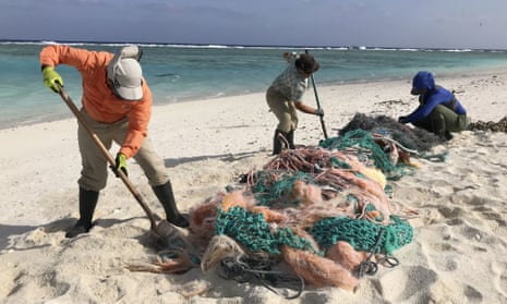 Matt Butschek, left, Charlie Thomas, centre, and Naomi Worcester clean up fishing nets in the Northwestern Hawaiian Islands. They have been cut off from the rest of the planet since February.