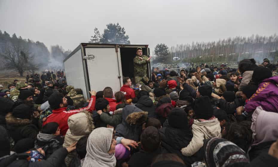 Migrants wait for humanitarian aid from the Belarusian military at a camp at the Belarus-Polish border.