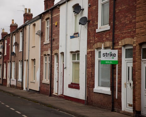 A row of terraced houses in different colours line a quiet Hartlepool street under an overcast sky