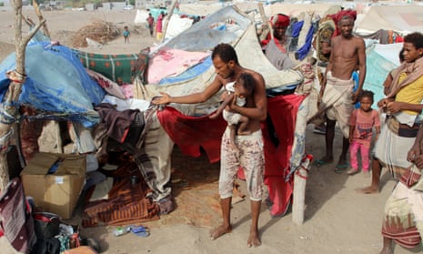 People displaced by the war in Yemen’s west coast areas gather outside their tent at a camp near Aden, Yemen, on 27 May 27.