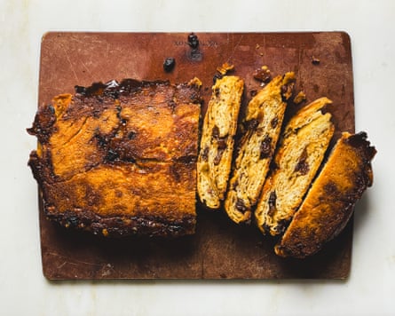 A loaf of cake that is half sliced.