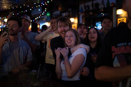 people grin and cheer successful a bar