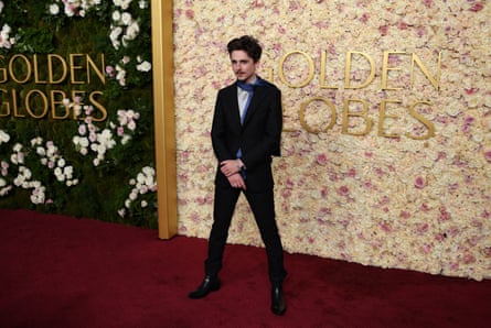 Timothée Chalamet in a slim-fitting suit, white shirt and thin blue scarf