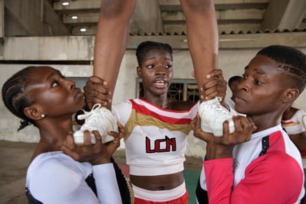 Three members of the Lagos Cheer Nigeria cheerleading team, including Eniola Aluko, 21 (centre), hold up another member 