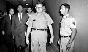 Ali is escorted from as US army facility after refusing army induction over his opposition to the Vietnam war.