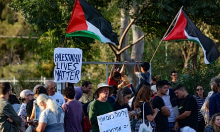 people hold palestinian flags and protest signs 
