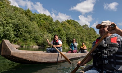 People holding oars in a canoes on a river