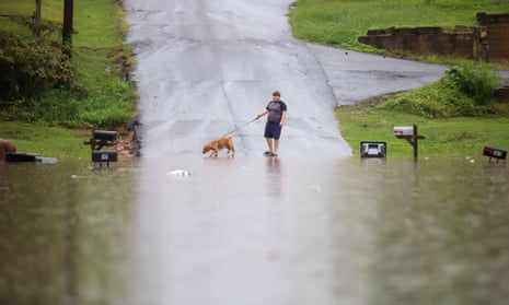 A young man walks his dog along a flooded Bittings Avenue on Sunday in Summerville, Georgia.