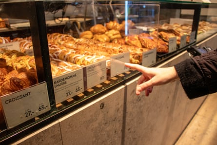 A hand points out pastries in a bakery