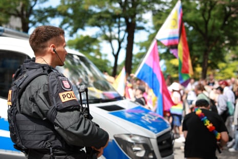 An armed police officer stands near the Hamburg pride parade.