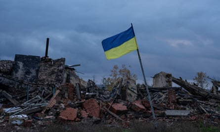 Ukrainas karogs plīvo virs Ukrainas un Krievijas okupācijas spēku kauju laikā nopostītajām ēku drupām Harkovas apgabala Kamjankā.