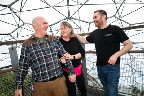 Liz Hill is holding on to Vernon’s arm; the three of them are smiling