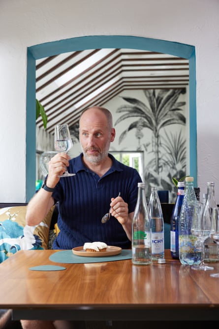 Simon Usborne, sitting with a plate of dessert, holds up a glass of water