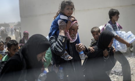 Syrian refugees carry children and bottles of water to the Akçakale border crossing