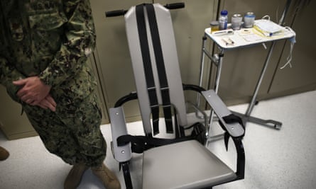 A U.S. Navy nurse stands next to a chair with restraints, used for force-feeding, and a tray displaying nutritional shakes, a tube for feeding through the nose, and lubricants during a tour of the detainee hospital at Guantanamo Bay Naval Base in Cuba. (AP Photo/Charles Dharapak, File)