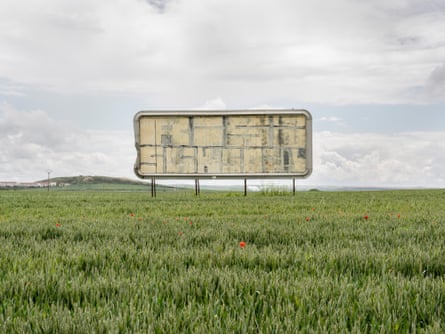 An empty billboard in the middle of a wheat field