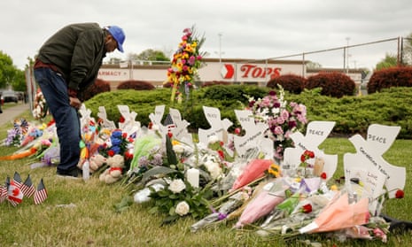 A man mourns at a memorial at the scene of a shooting at a Tops supermarket in Buffalo, New York on 20 May 2022. 