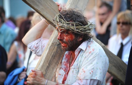 Actor Michael Sheen carrying a cross and wearing a crown of thorns in The Passion, 2011