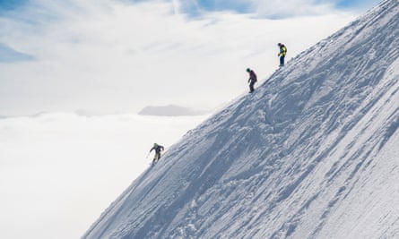 Skiers on steep snowy slope