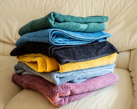 colorful bath towels folded and stacked on a sofa