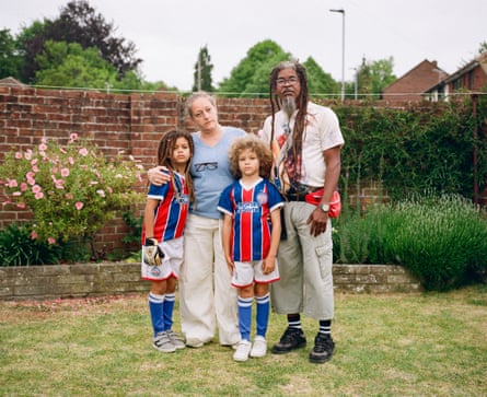 The family pose for a photo standing in a garden