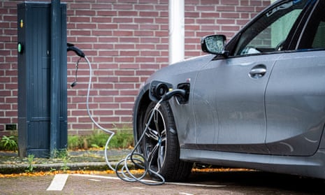 An electric BMW being charged at a car park charging point