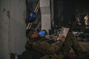 A soldier completes a crossword during a lull in fighting.