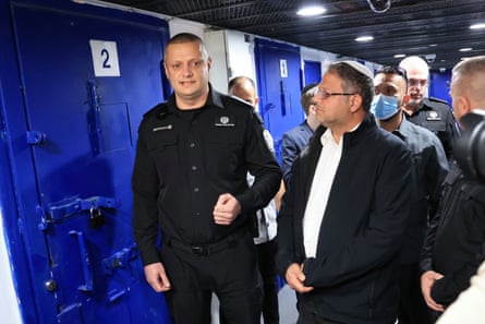 Itamar Ben-Gvir and other men standing in a corridor outside blue numbered doors