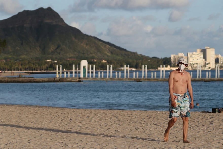 A beachgoer wearing a protective mask in Honolulu, Hawaii. The state has maintained some of the lowest levels of Covid-19.