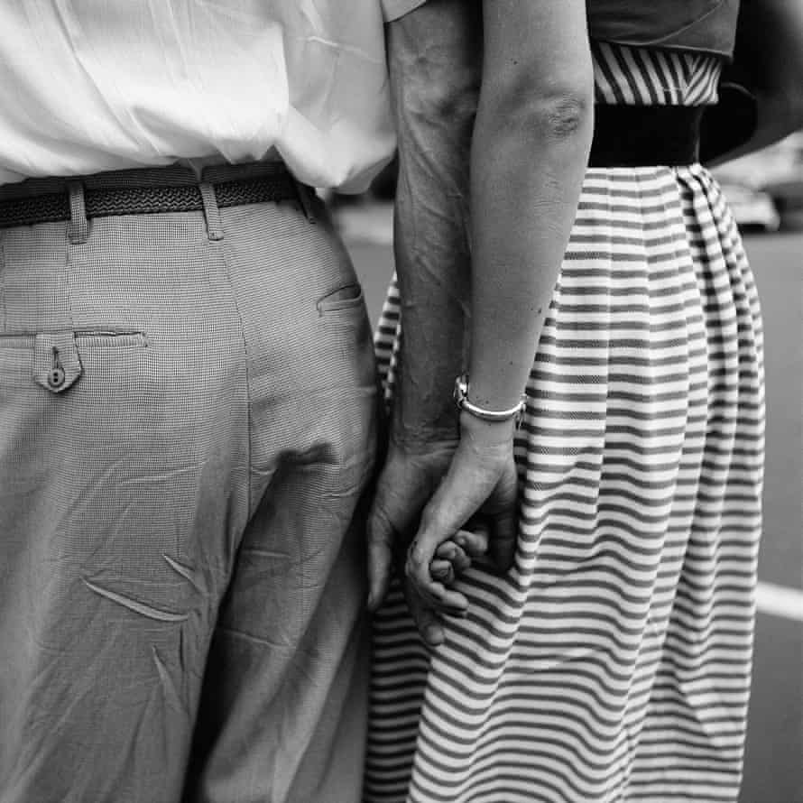 A couple holding hands, in New York, 1954, shot mid-height from the back.
