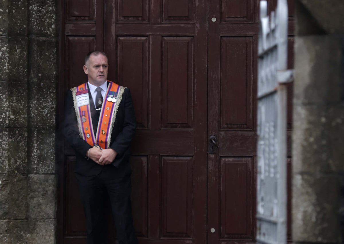 A member of the Orange Order outside Drumcree Parochial Hall in Portadown ahead of the march