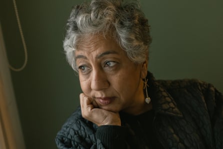 An older woman rests her head on her hand