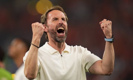 Gareth Southgate wearing white short sleeve shirt punches air with both hands and cheers