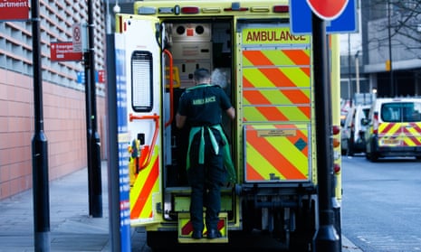 A paramedic helps an elderly from an ambulance outside the emergency department of the Royal London Hospital in January 2021