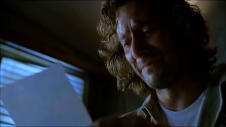 Desmond in a dark room, reading a letter from Penny