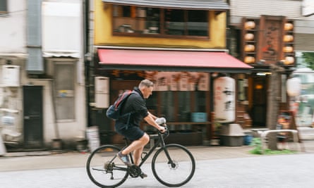 Hammy sitting on Justin McCurryâs handlebars as they cycle through the Tokyo streets