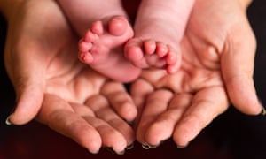 A mother holding the feet of a new baby