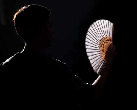 A person uses a hand fan during a heatwave in Brussels, Belgium.