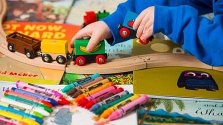 A child playing with a train set and other toys