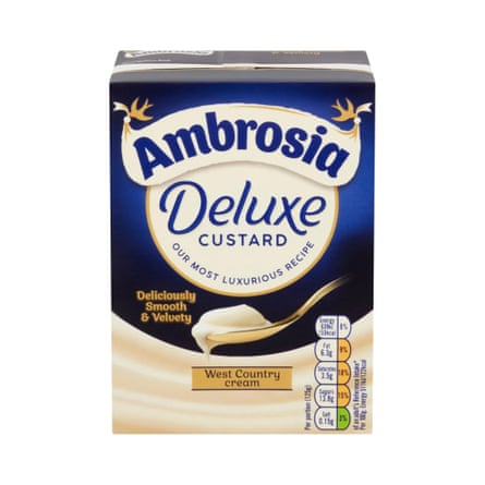 A carton of Ambrosia Deluxe custard shows a spoonful of creamy custard dripping