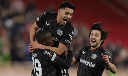 Moussa Diaby wordt lastiggevallen door teamgenoten Sardar Azmoun en Nadiem Amiri na het scoren van de winnende penalty voor Bayer Leverkusen.