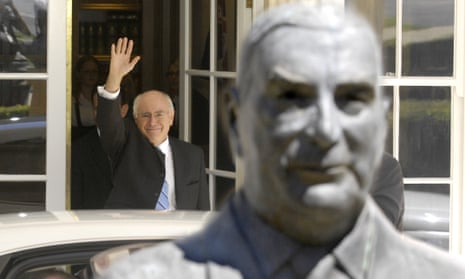 John Howard waves behind a bust of Sir Robert Menzies