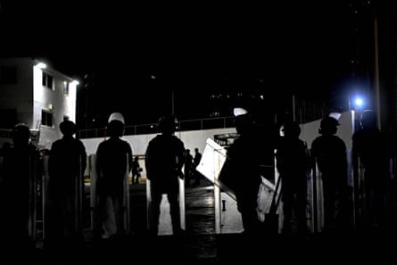 riot police officers stand guard outside a detention centre