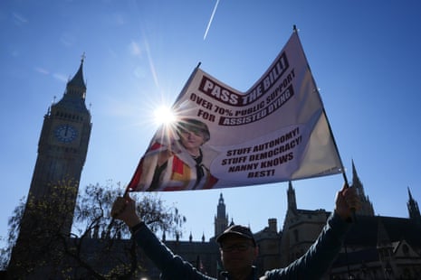 A campaigner holds a banner outside parliament showing support for the assisted dying bill.